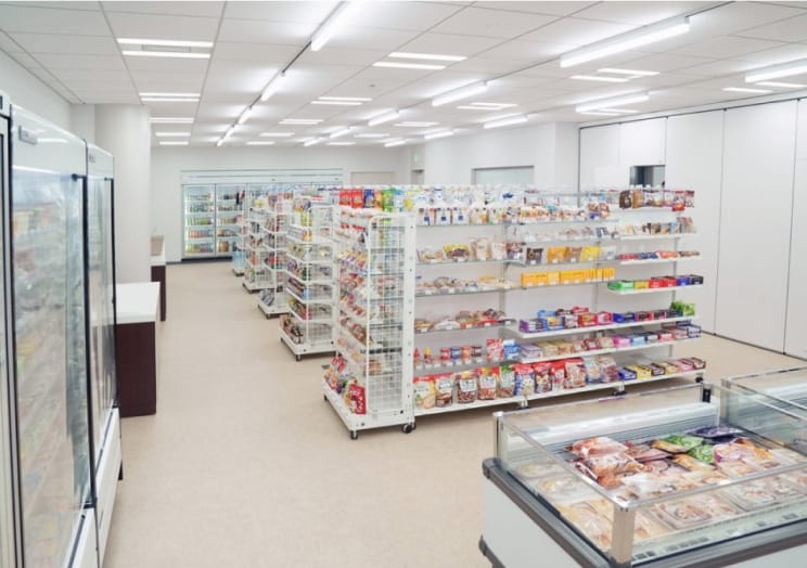 陳列棚と商品が並ぶ模擬店舗会場（コンビニ形式）